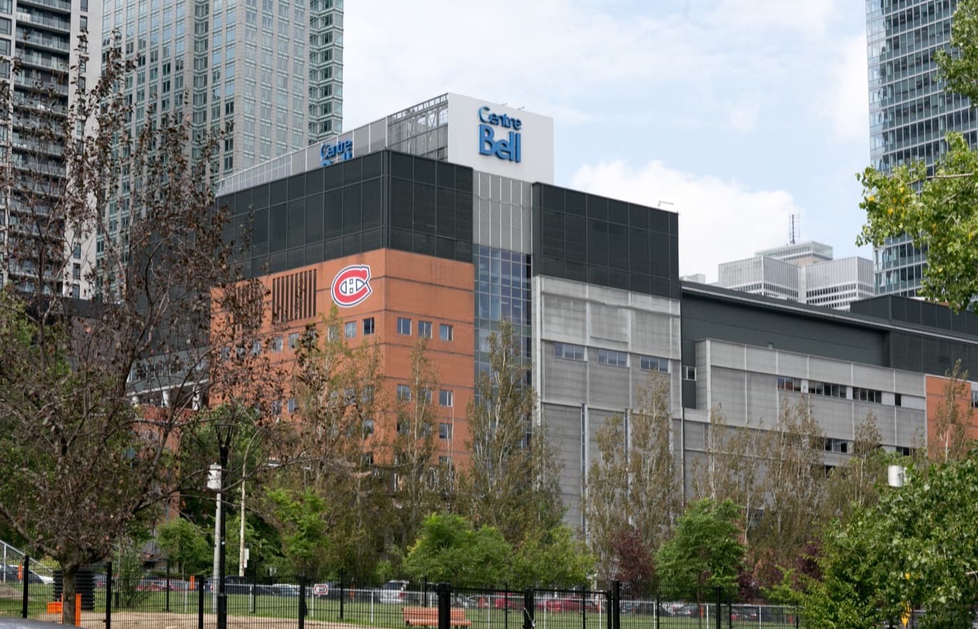 A street-level view of the Bell Centre in downtown Montréal, with the lit Centre Bell sign and the Canadiens logo on the facade