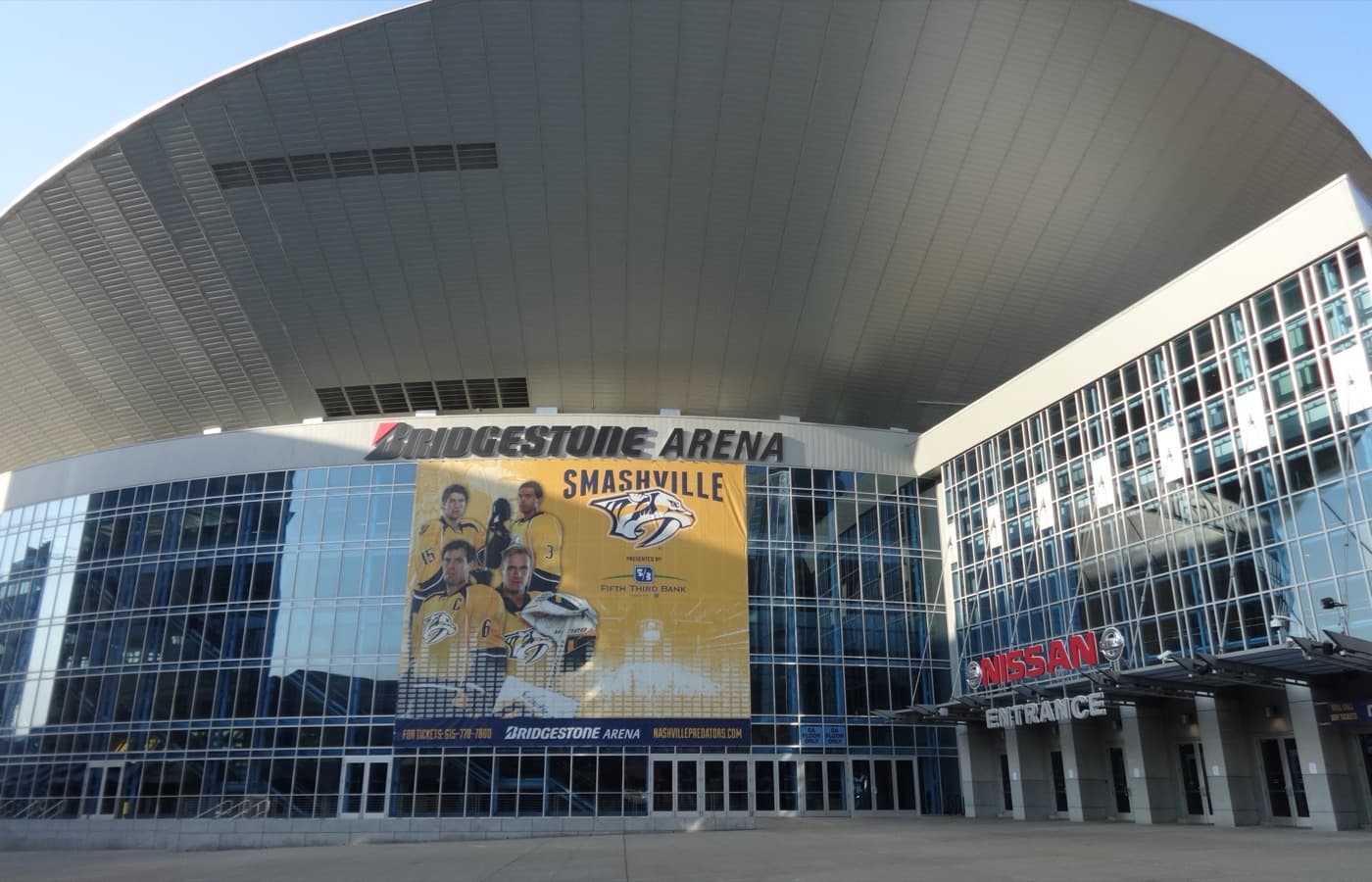 Exterior of Bridgestone Arena in downtown Nashville, showing the Nissan entrance and a Smashville banner on the building’s glass facade