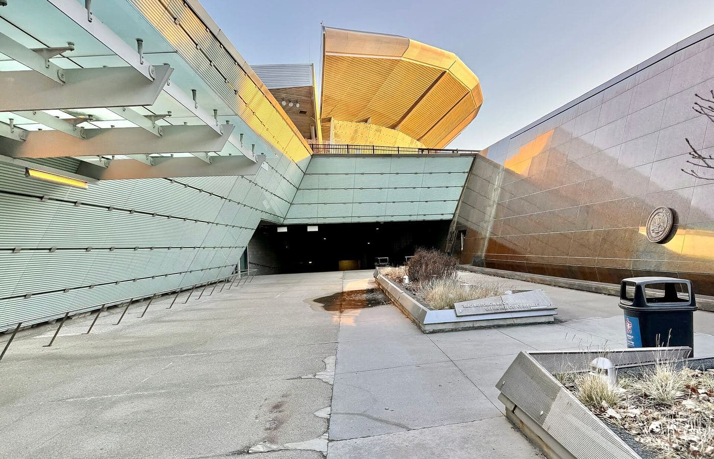 Soldier Field’s steel-and-glass upper bowl rising above an entrance plaza in low sun