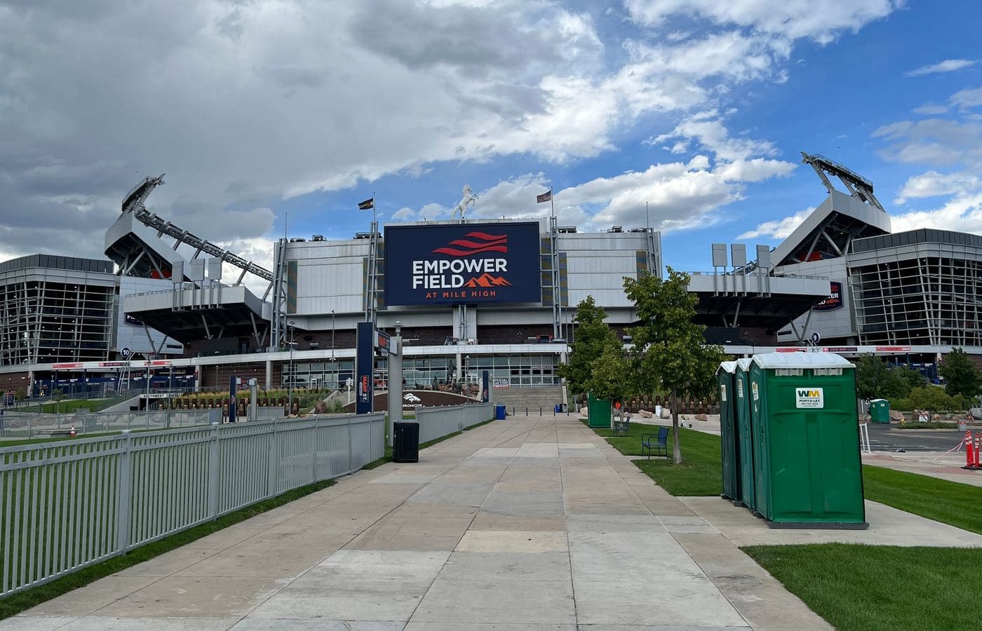 The main entrance of Empower Field at Mile High, with its scoreboard sign and white horse statue above a wide walkway