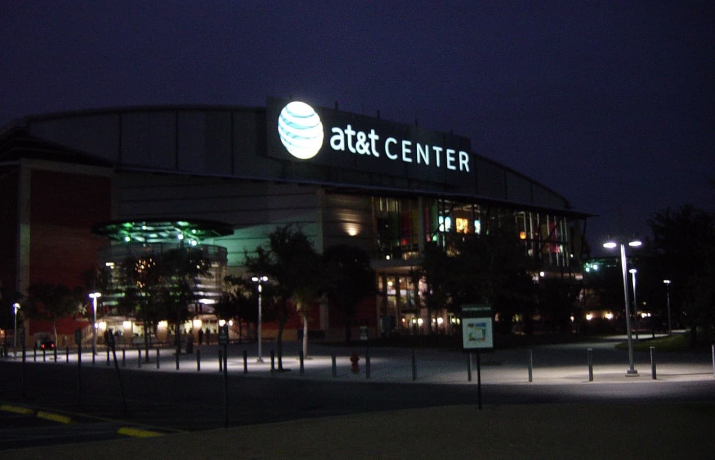 The San Antonio arena now called Frost Bank Center, lit up at night; the photo predates the 2023 renaming and shows its former AT&T Center signage