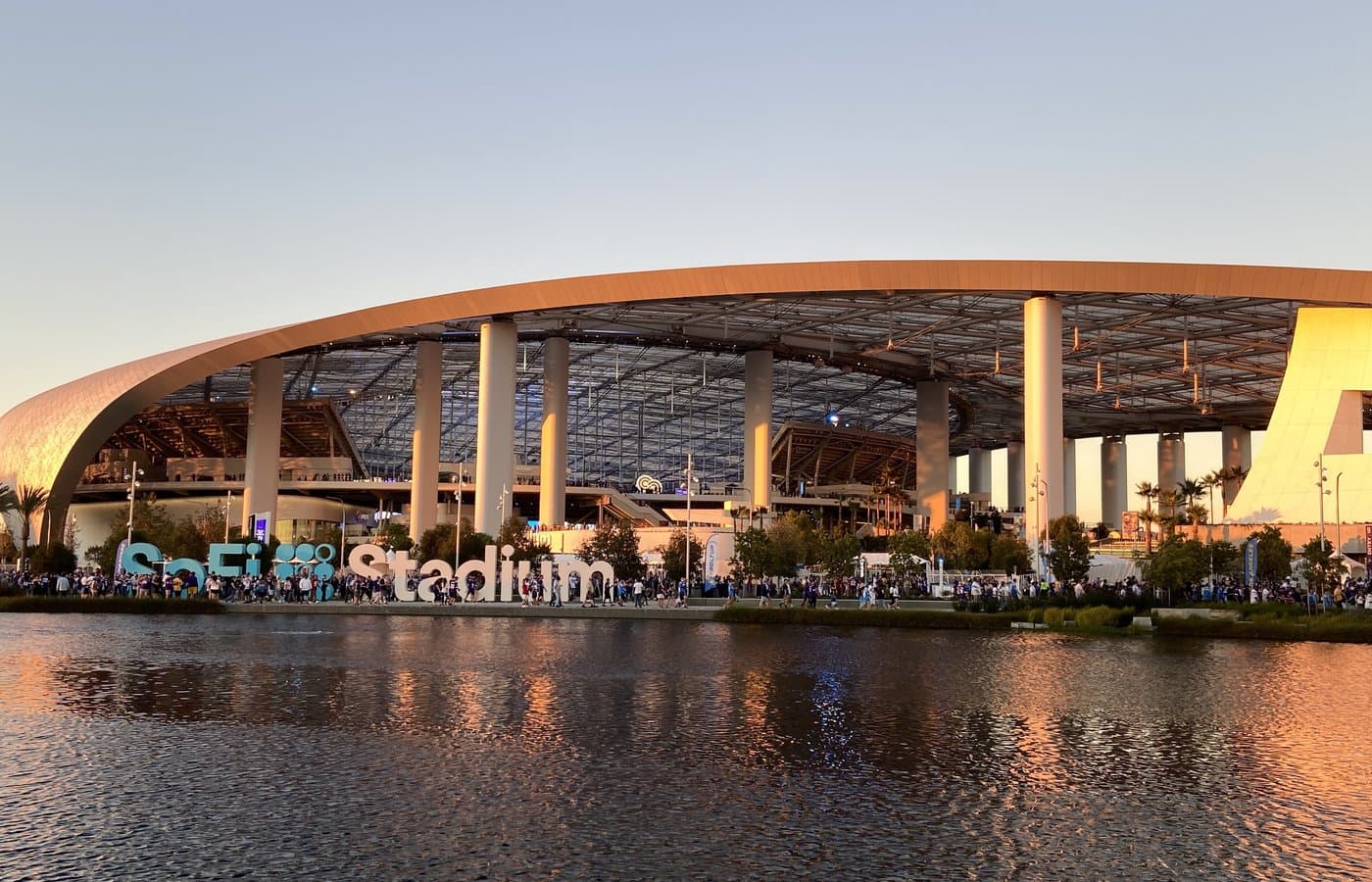 SoFi Stadium exterior at sunset across the lake