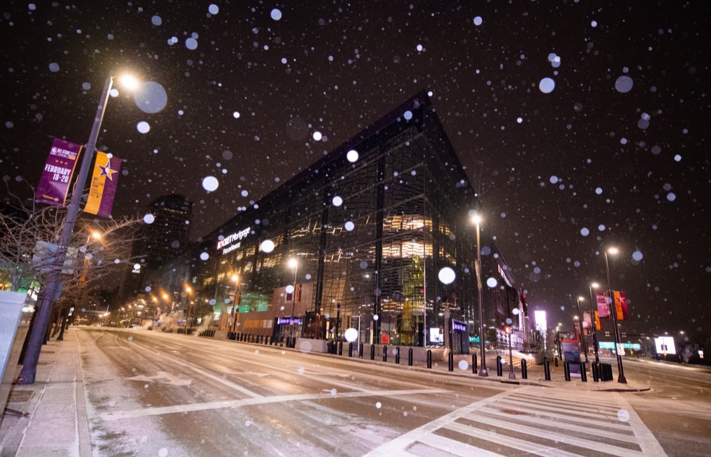 Rocket Arena’s glass exterior on a snowy night in downtown Cleveland, with signage showing its former name, Rocket Mortgage FieldHouse