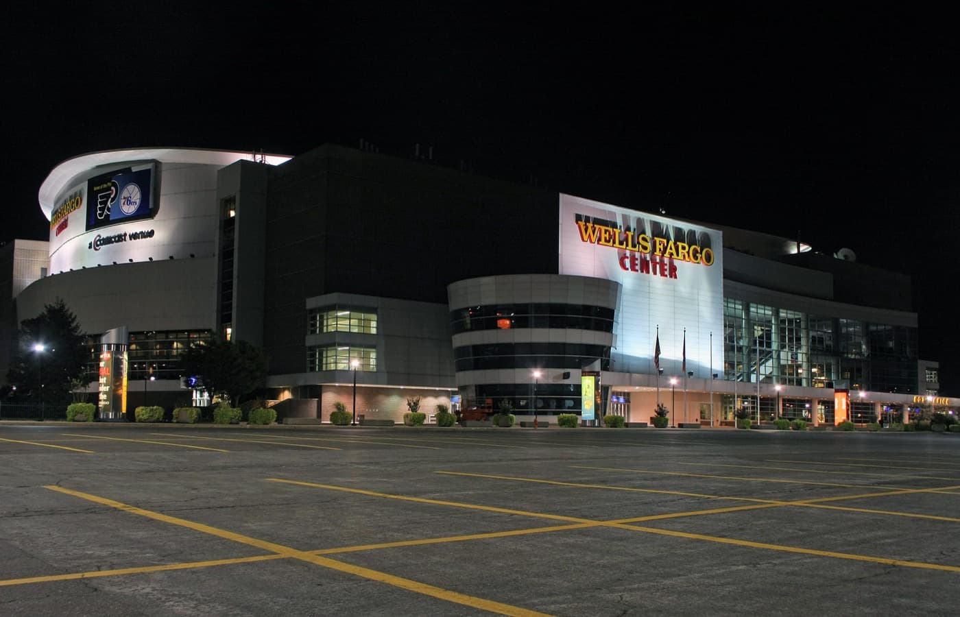 Xfinity Mobile Arena at night, then signed as the Wells Fargo Center, seen across an empty parking lot in South Philadelphia